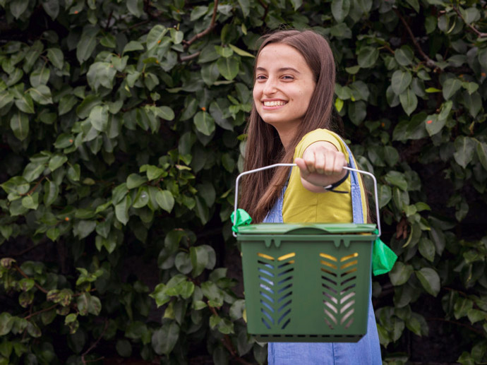 Girl smiling and holding a bucket